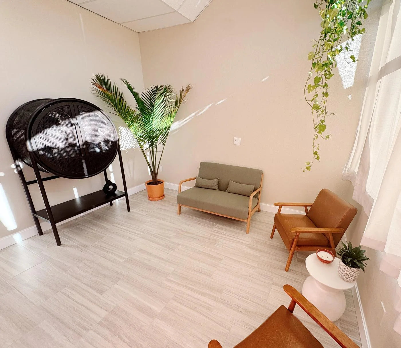 The real Brook Hollow lounge with warm chairs, plants and natural light